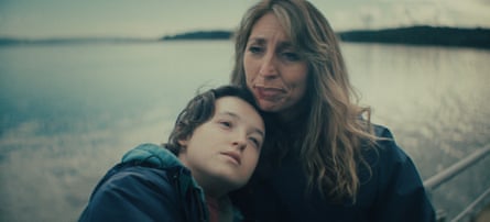 Bell Ramsey snuggling her head into Daisy Haggard’s neck as they both look into the middle distance, with the sea behind them