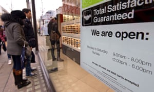 Shoppers look at the window display of a Vision Express store on Oxford Street