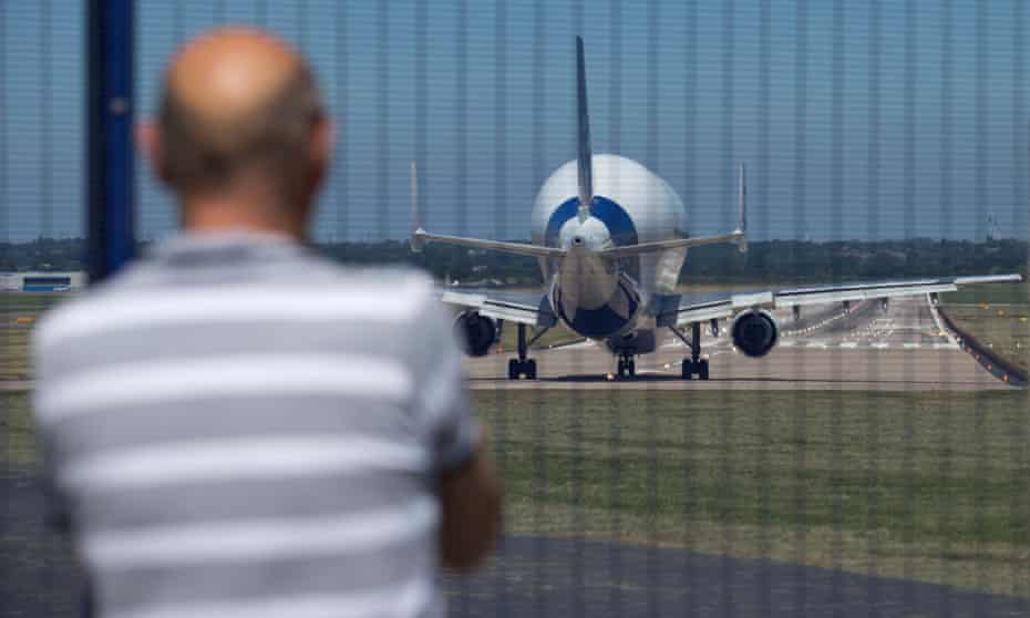 A man watches an Airbus A300-600ST prepare to take off from its factory in Wales