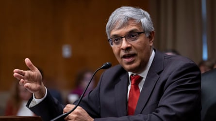 Jay Bhattacharya, wearing a suit, talks before some sort of hearing with a small mic in front of him