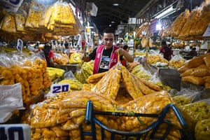 A worker transports bags of chrysanthemums at a flower market