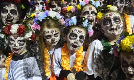 Children take part in the carnival in Derry, for Halloween, their faces painted as ghouls and zombies.