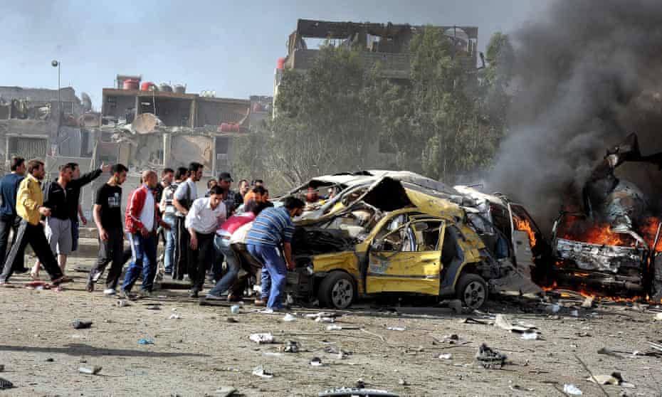 Locals rush to help victims of two suicide bombs in Damascus, Syria, May 2012