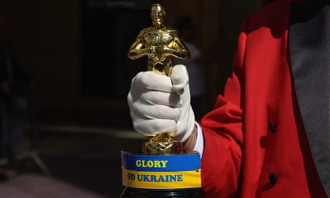 Gregg Donovan holds up an Oscar statue with a sign reading ‘Glory To Ukraine’ ahead of the Oscars Award show at the Dolby Theatre on Hollywood Boulevard in Los Angeles, California.