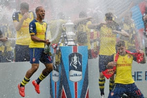 Theo Walcott and the other Arsenal players celebrate with the trophy after the 2015 FA Cup Final.