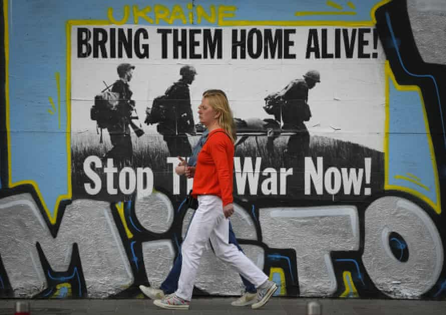 Deux femmes passent une affiche anti-guerre à Kiev