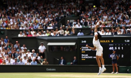 Carlos Alcaraz serves against Novak Djokovic.