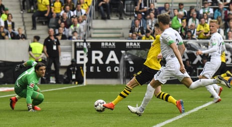 Marco Reus, centre, slots the ball past Mönchengladbach keeper Yann Sommerscores his Dortmund’s second goal .