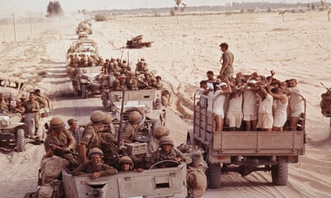 Captured Egyptian soldiers pass an Israeli troop convoy in the Sinai desert on 8 June 1967.