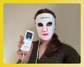A woman wears a white LED face mask while holding its lit controller device