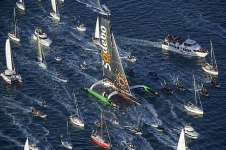 Sailors surround Thomas Coville’s Sodebo trimaran as he approaches the port of Brest.