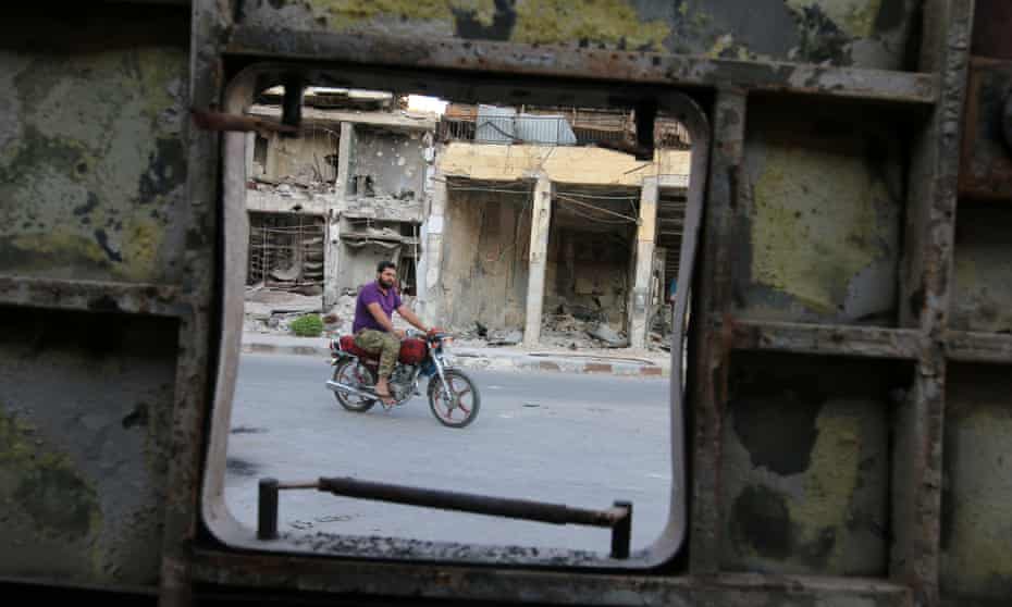 A man rides a motorcycle near damaged buildings in the rebel-held Old Aleppo where a ceasefire came into effect on Monday.