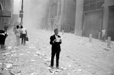A man picks up and begins to read a piece of paper blown out of the World Trade Center in the aftermath of the attacks. New York City, USA, September 11, 2001