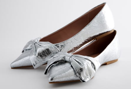 Pointed metallic silver ballet slippers with a big bow on the top