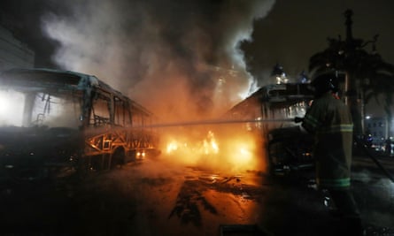 A firefighter works douses a burning bus in Rio.