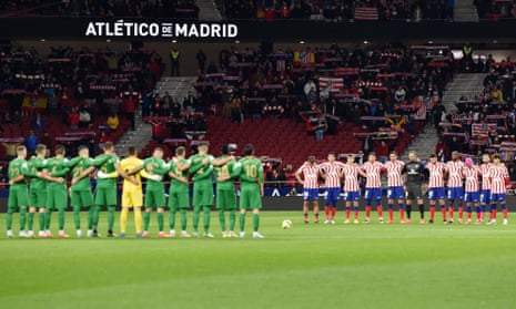 Atlético and Elche players and fans take part in a minute’s silence in Madrid.