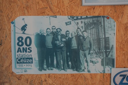 A cutting on a wooden board with a black and white photograph of a group of men next to writing in French that reads “80 ans station Céüze 1935-2015”.