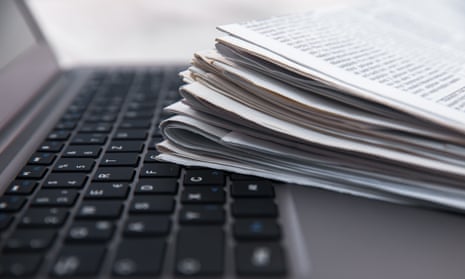 Newspapers rest on a laptop keyboard