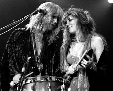 Two women with 1970s shaggy hairstyles perform on stage close to each other