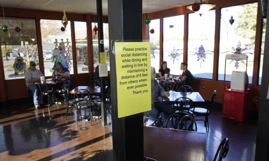 A sign advising patrons to maintain social distancing is posted in the indoor dining area of the San Francisco Deli in Redding, California.