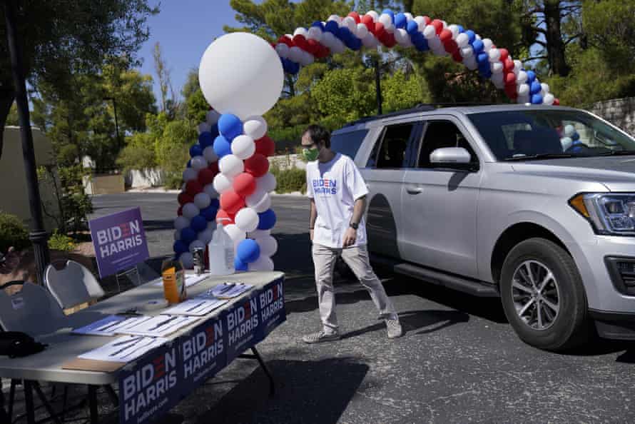 Craig Bakerjian hands out campaign face masks, signs and shirts in support of Joe Biden at a drive-thru station in Las Vegas on 29 September.