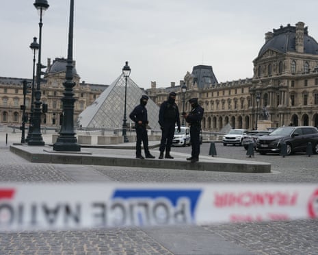 French police officers patrol in front of the Louvre Museum after it was robbed.