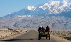 Passengers sit in an open topped vehicle on the Karakoram Highway,