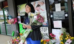 Ashley Zhang takes a moment before laying flowers at a makeshift memorial outside Youngs Asian Massage in Acworth, Georgia.