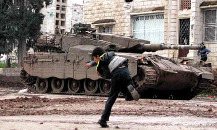 Un niño palestino arroja piedras a un tanque en Jenin, 2003.