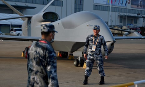 People's Liberation Army soldiers stand near a drone