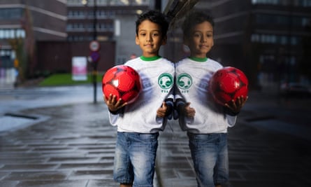 England’s united nations of football: 32 teams, one World Cup – and a lot of excited kids | World Cup 2022 27 Rowaid Mohammed Islam wearing a Saudi Arabia shirt and holding a football, standing against a wall in which his reflection can be seen
