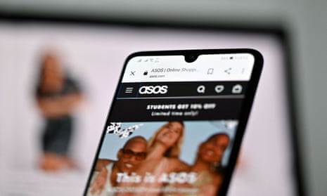 Laptop and mobile phone show the website of online fashion retailer ASOS with an image of three people smiling