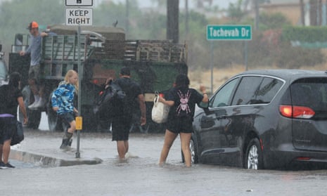 Motorists leave their vehicle on a flooded road in Palm Springs.