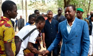Togolese president Faure Gnassingbé shakes hands with voters at the polls.
