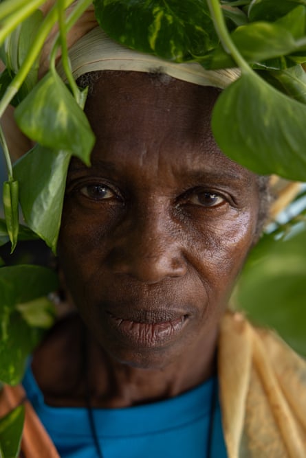 a woman's face looks out from among leaves