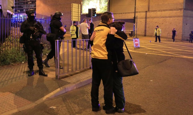 A man and woman hug on the streets of Manchester.