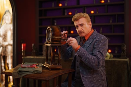 A man tinkers with the back of an old-fashioned looking clock.