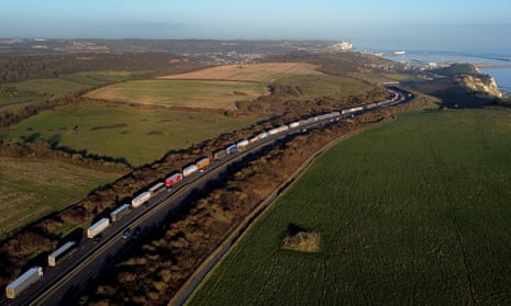 Long line of lorries for Dover port along a coast road.