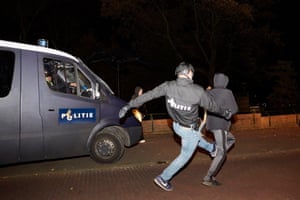 A police officer tries to catch a rioter.