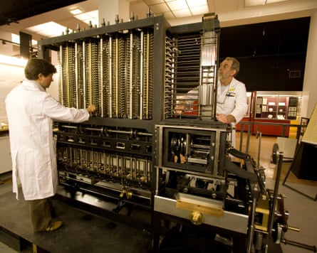 Two engineers in white coats working on a model of the difference engine at the Science Museum in the 1990s