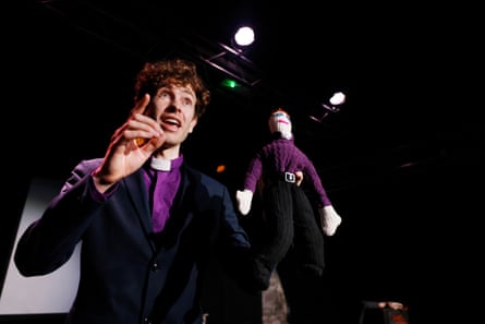 A man dressed in a black suit and a purple shirt and white dog collar