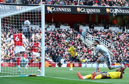 James Justin (centre) watches as his shot goes into the net as an Arsenal defender jumps at the ball