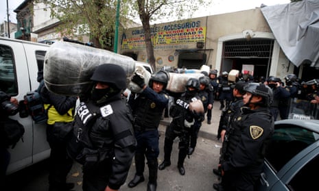 Police carry sacks of marijuana out of a raid at an alleged drug laboratory at Tepito in Mexico City. Twenty-seven suspected cartel members arrested during the raid were freed. 