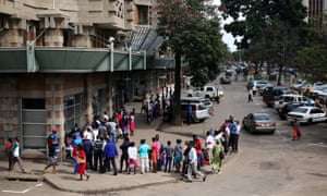 Customers queue to withdraw money at a bank in Harare.