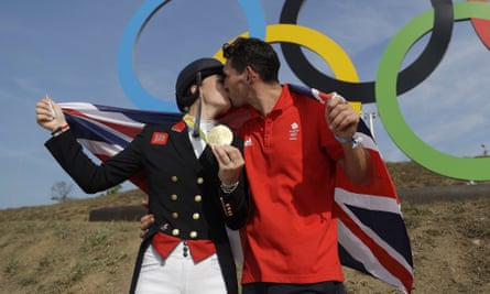 Britain’s Charlotte Dujardin, left, poses for with her partner, Dean Golding, after she won a second gold.