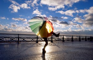 Dancing with the wind. A girl with a brolly fights the wind on her way to work on Hove promenade in Brighton, 2004