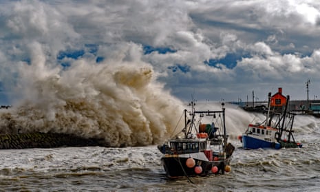 Fishing trawlers face treacherous conditions as waves crash against the harbour wall in Folkestone, England.