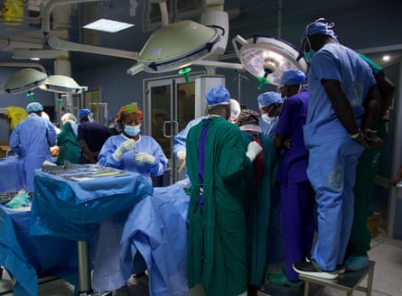 Ghanaian nurses gather to watch a surgical procedure in an operating theatre.