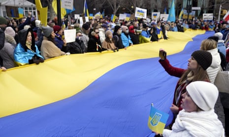 Demonstrators unfurl a large Ukraine flag across the street from the United Nations, 24 February.