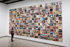 A staff member looks at a display of records on a wall